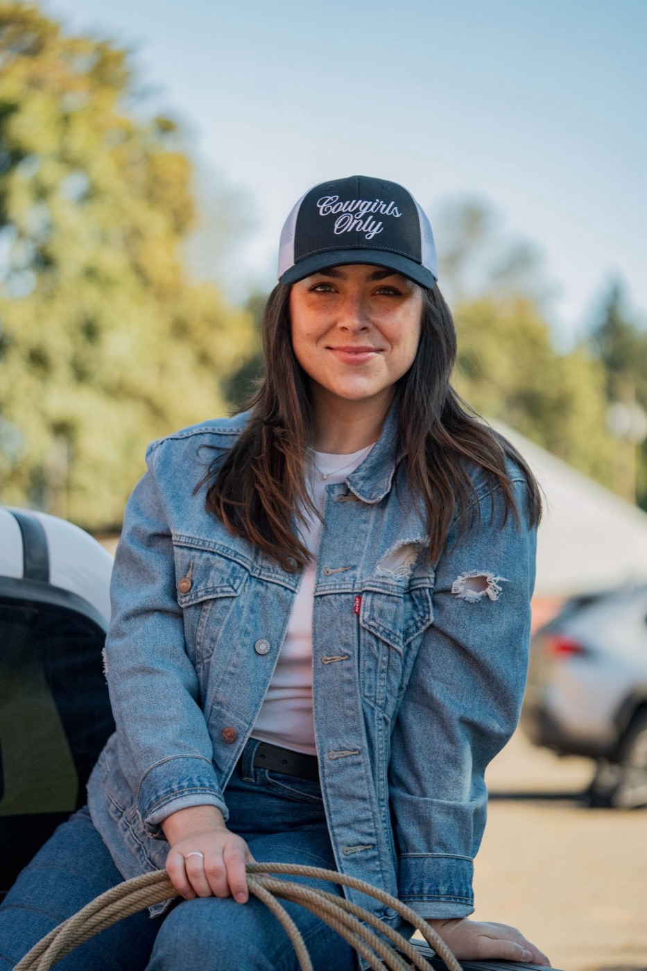 Model in a Cowgirls Only cap holding a rope