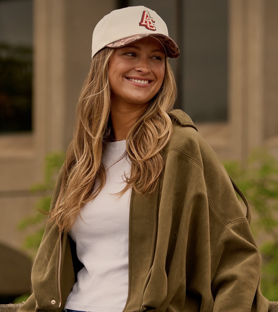 Smiling model in a cream and duck camo cap